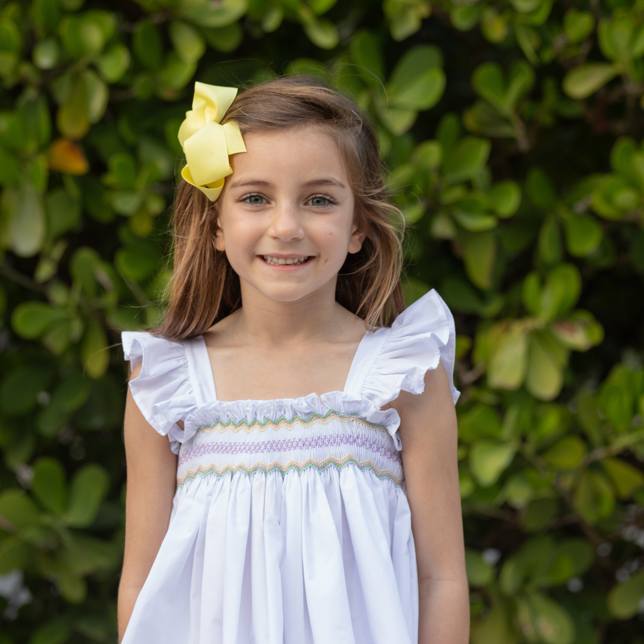 Henry Duvall girls smocked shorts set in Classic White, a classic two-piece outfit with flutter sleeves and blue embroidered smocking.