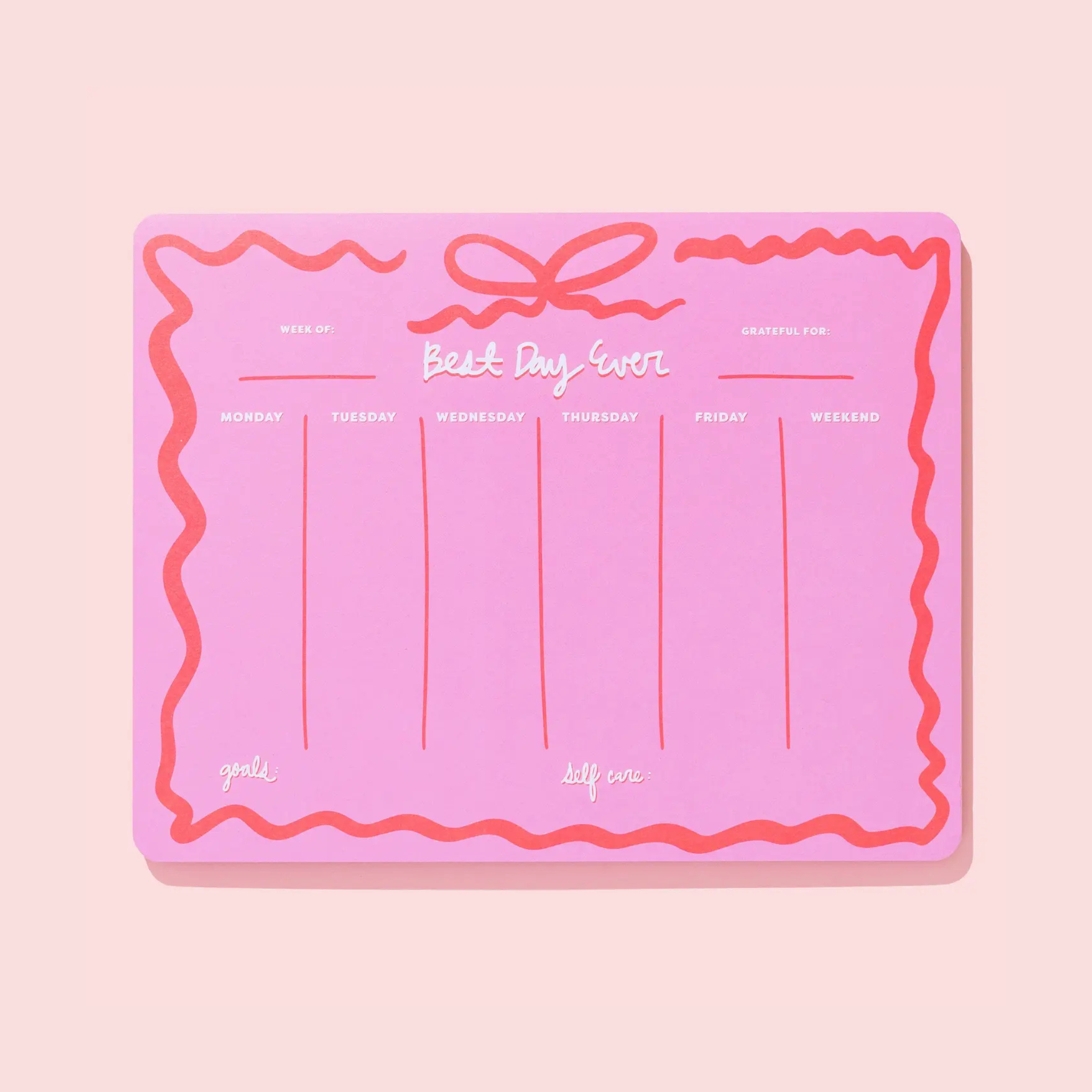 Hot pink weekly planner with bow detail, styled as a Christmas gift for girls ages 10–12