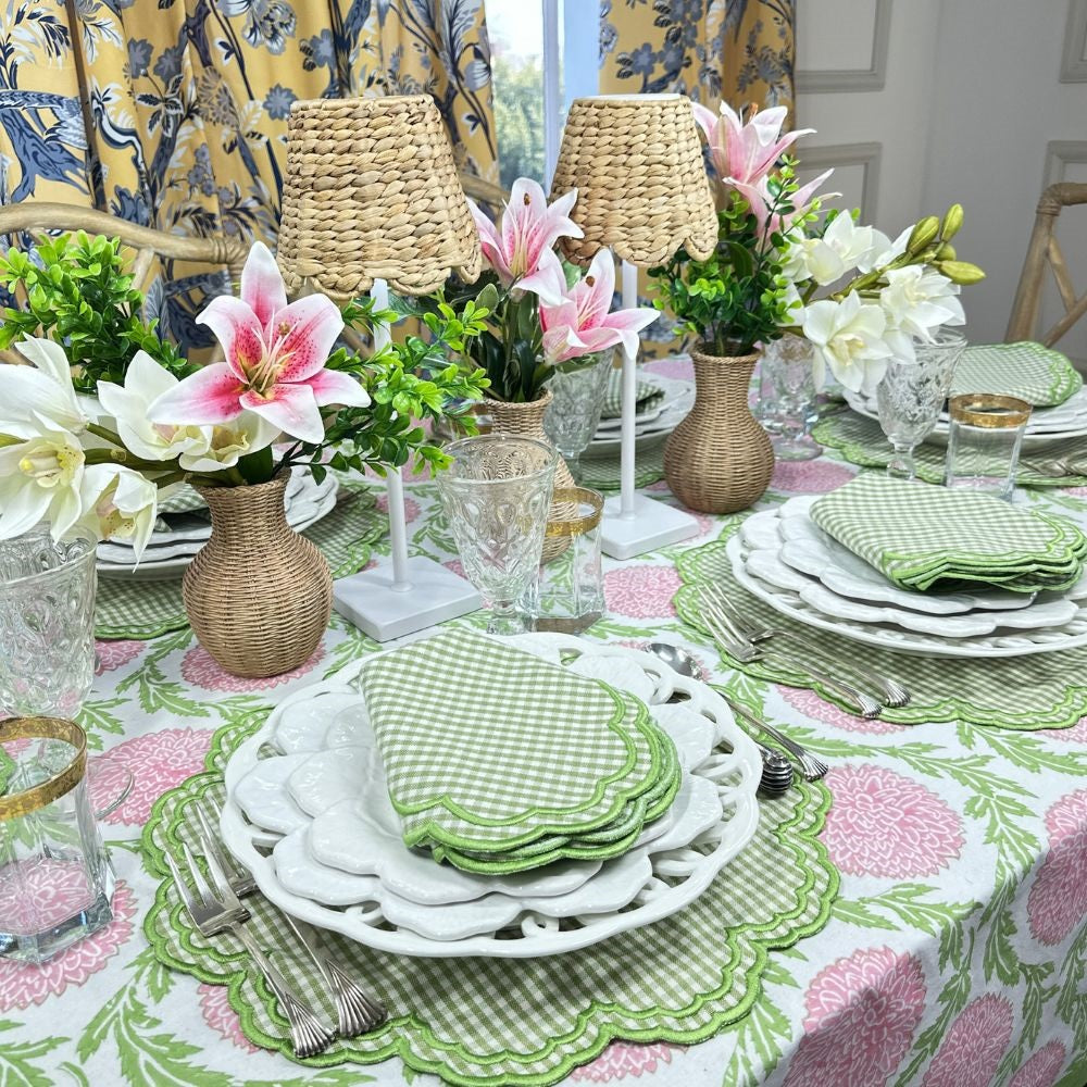 Elegant table setting with floral arrangements, green checkered napkins, and a patterned tablecloth.
