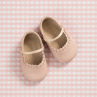 Elephantito baby ballet flats in white calfskin with scalloped trim and elastic strap, classic crib shoes for girls to pair with Henry Duvall outfits for portraits and baby showers.