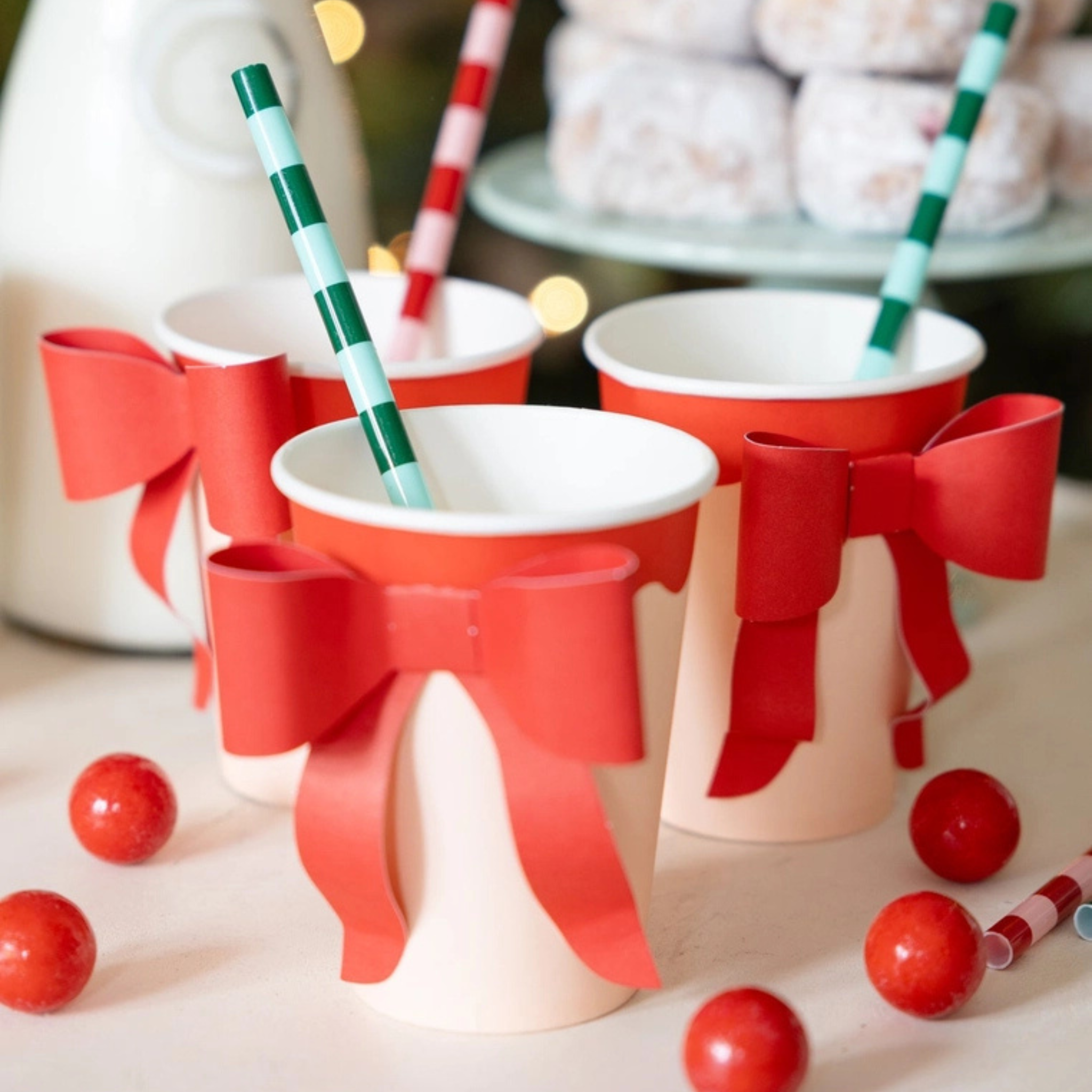 Red and pink paper party cup with a large red paper bow attached to the front, perfect for festive holiday gatherings.