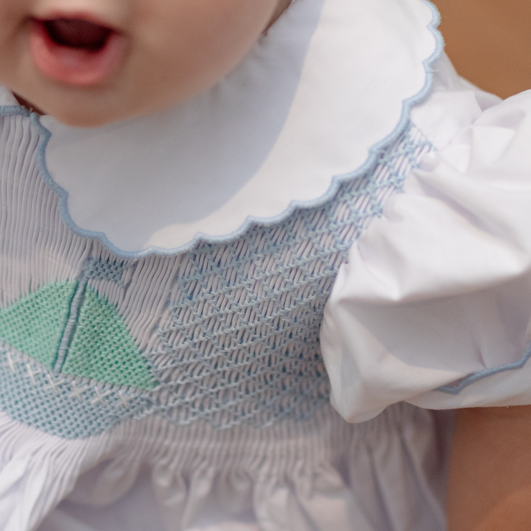 Henry Duvall Eloise Bubble in white cotton with Bailey’s Bay Blue trim and hand-smocked sailboats, classic heirloom baby girl summer outfit with scalloped Peter Pan collar