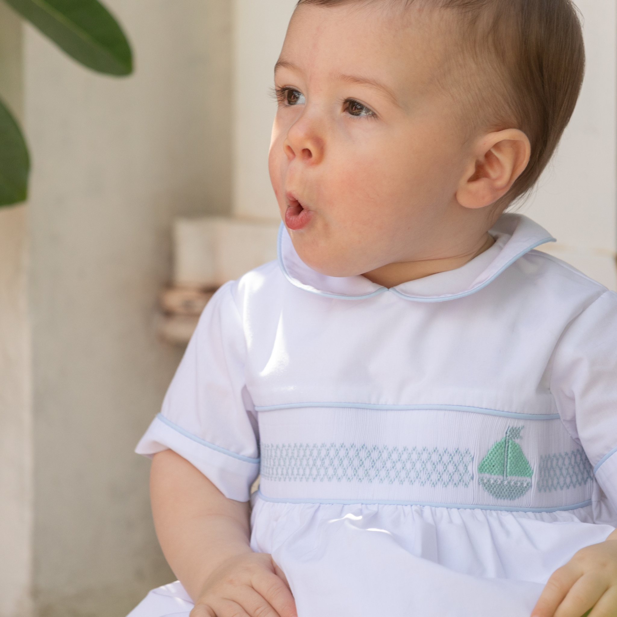 Henry Duvall Charlie Bubble for boys in white cotton with Bailey’s Bay Blue trim and smocked sailboat, classic summer baby boy outfit with Peter Pan collar