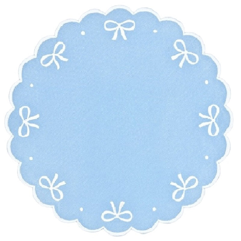 Round blue label with white scalloped edge and decorative bows on a white background