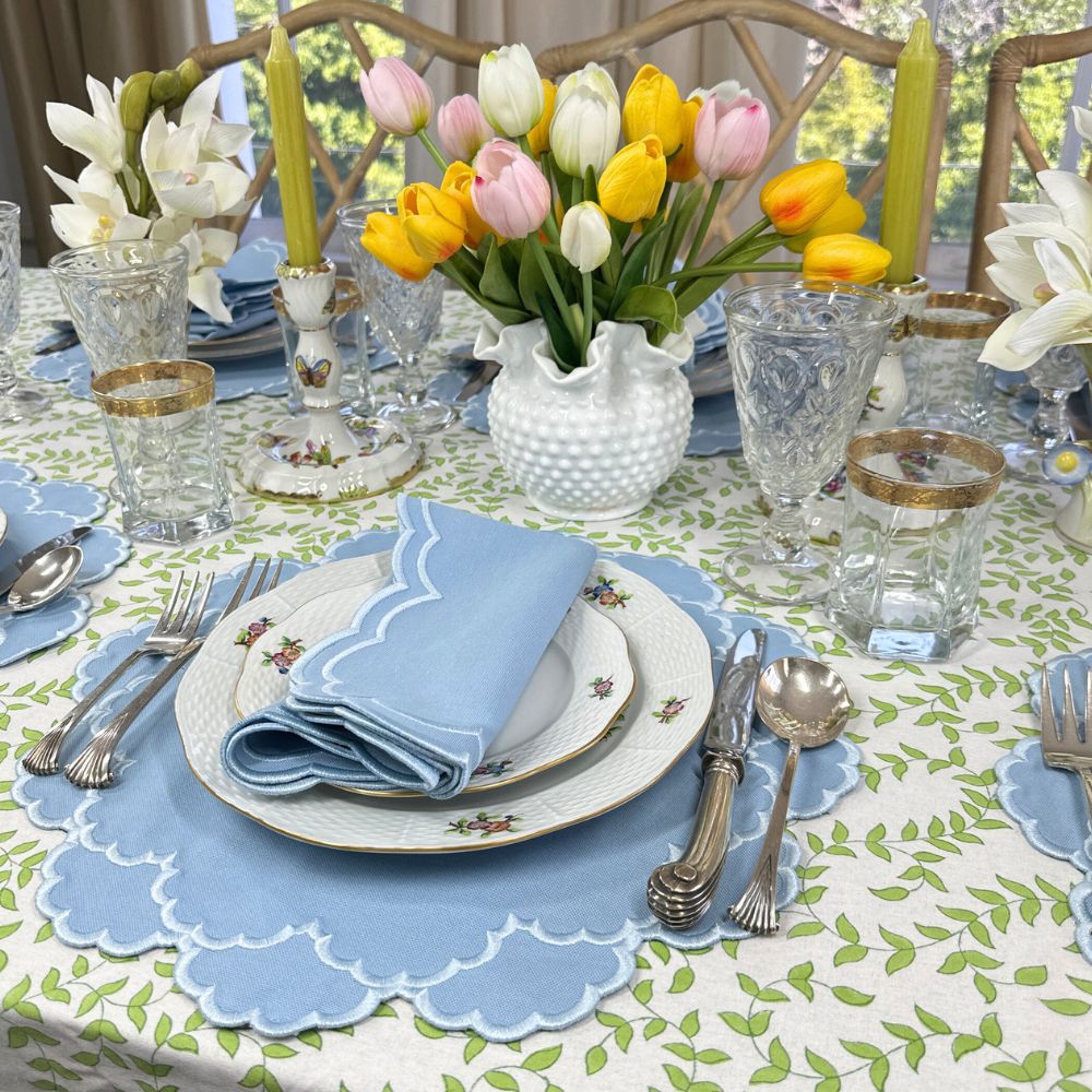 Easter table setting with tulips, floral centerpieces, and decorative plates.
