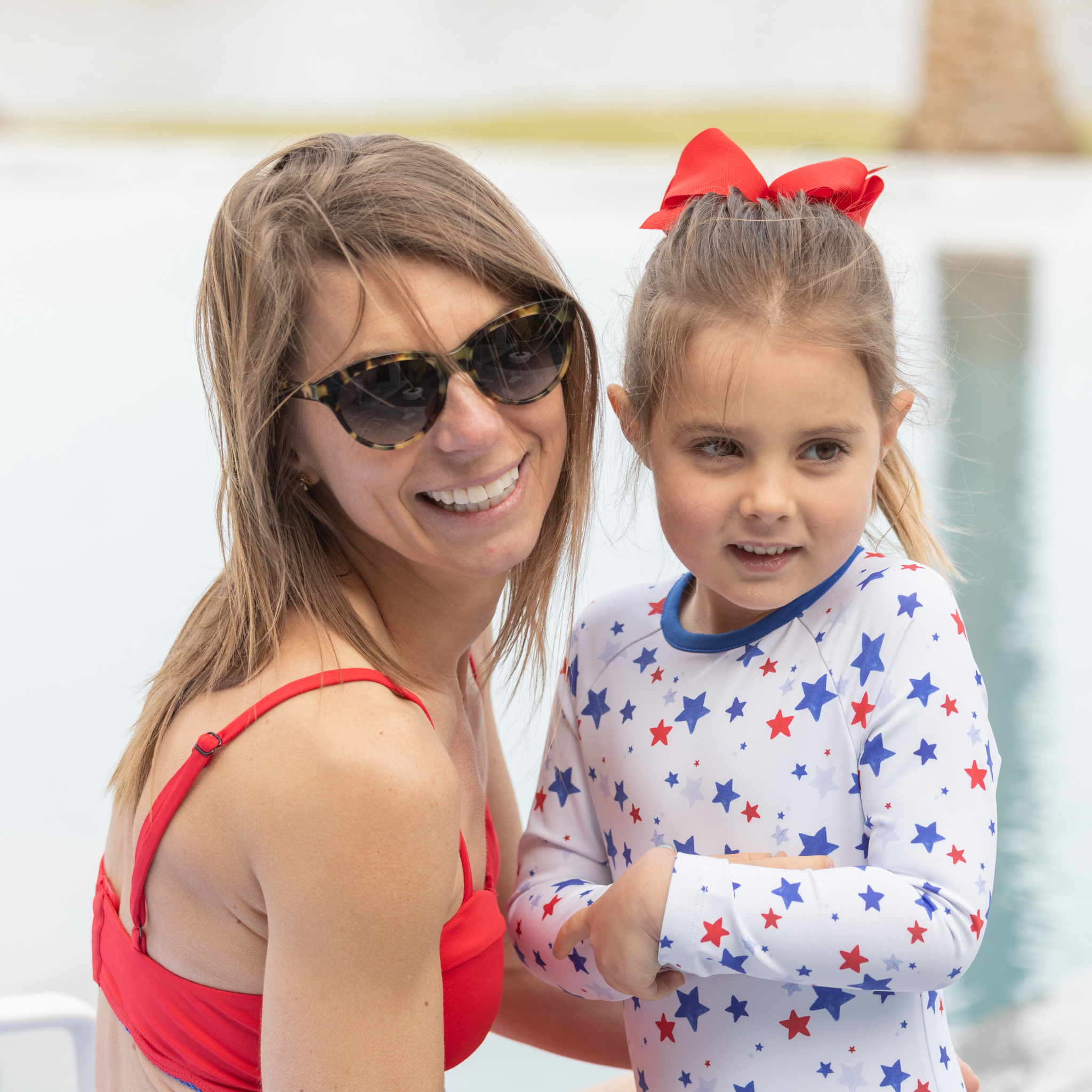 Henry Duvall Reese girls rashguard one piece in red white and blue star print, UPF 50+ long sleeve swimsuit for 4th of July, beach, and summer holidays