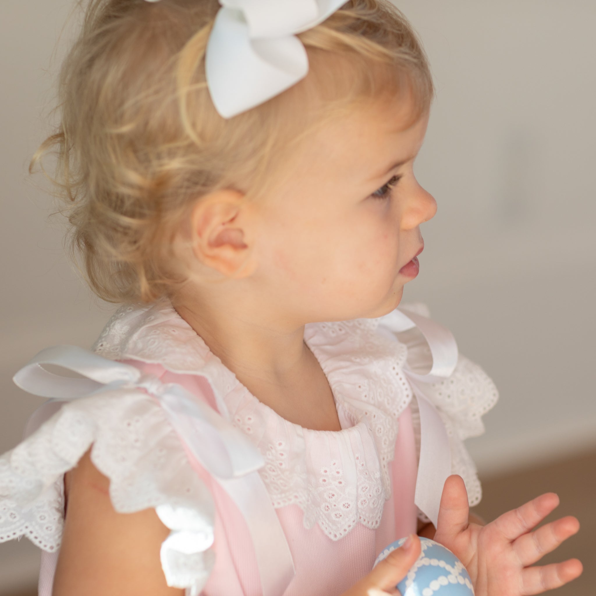 Toddler girl wearing the Henry Duvall Rosie Bubble, a classic pink bubble designed for spring days and special moments.