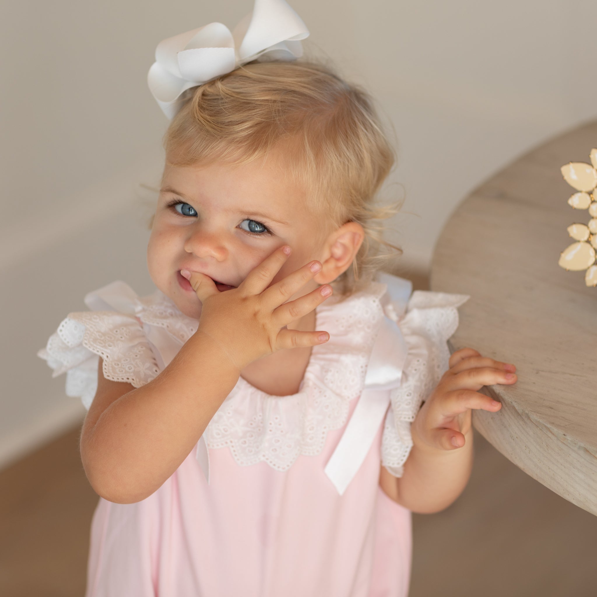 Toddler girl wearing the Henry Duvall Rosie Bubble, a classic pink bubble designed for spring days and special moments.