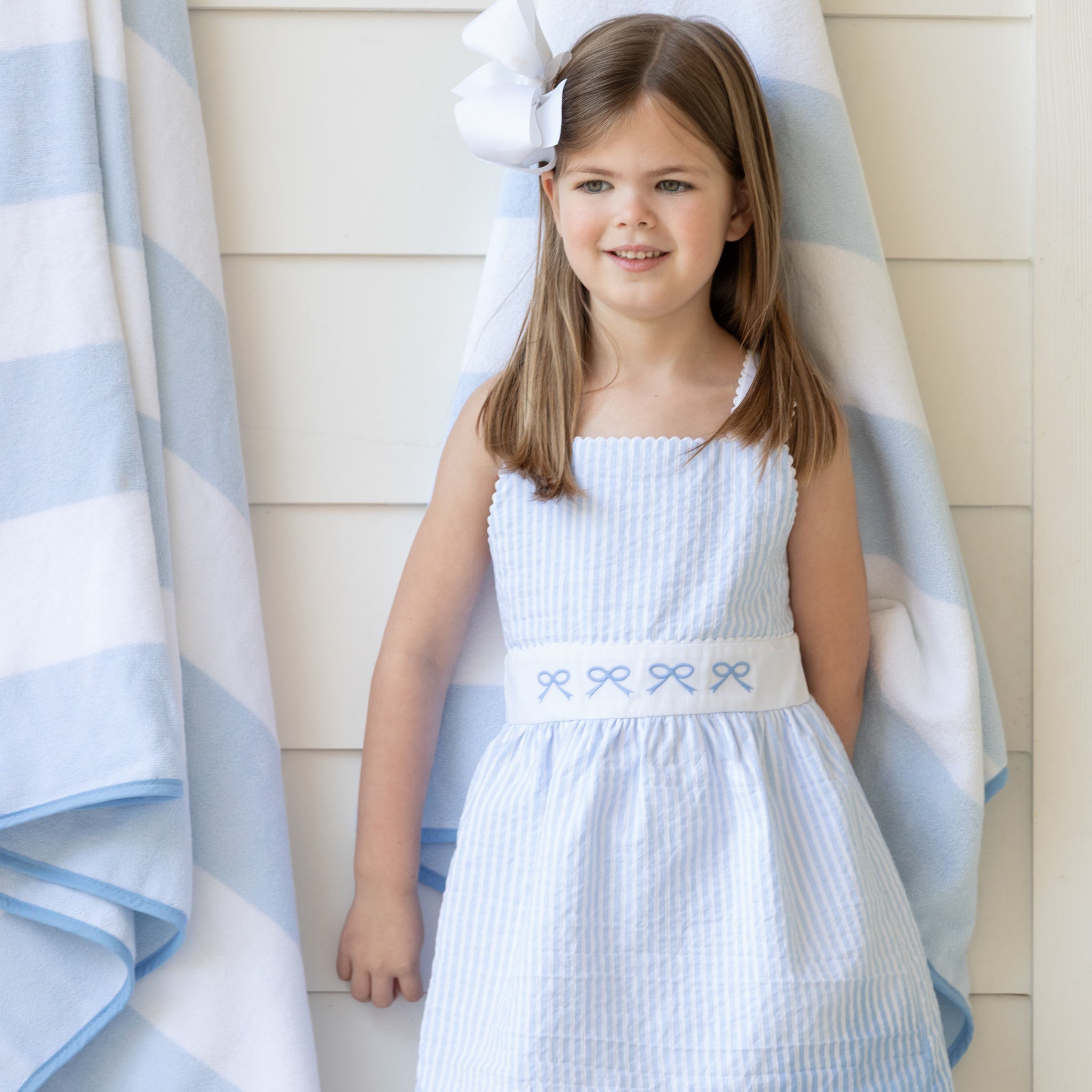 Girl wearing the Henry Duvall Campbell Dress in Seaside Stripe, a classic girls dress designed for warm weather and sibling matching