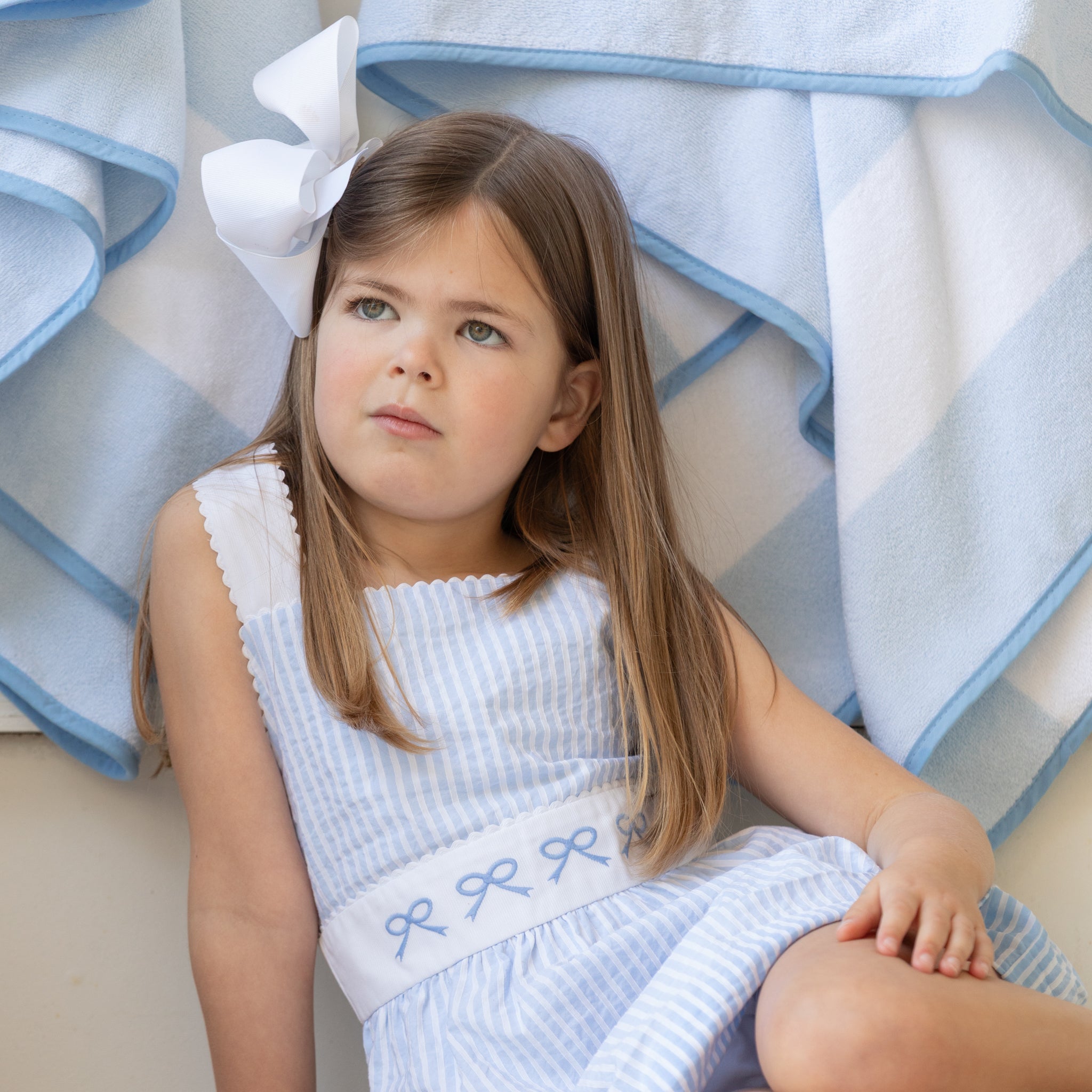 Henry Duvall girls Campell Dress in blue and white Seaside Stripe, a timeless summer dress with embroidered bow detail and open back straps