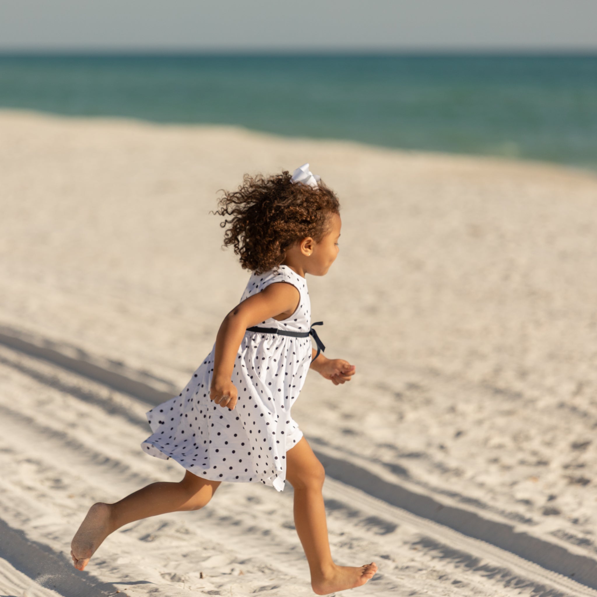 Henry Duvall Betsy Dress in white cotton with navy polka dots and grosgrain bow, classic twirl dress for girls that transitions from summer to fall