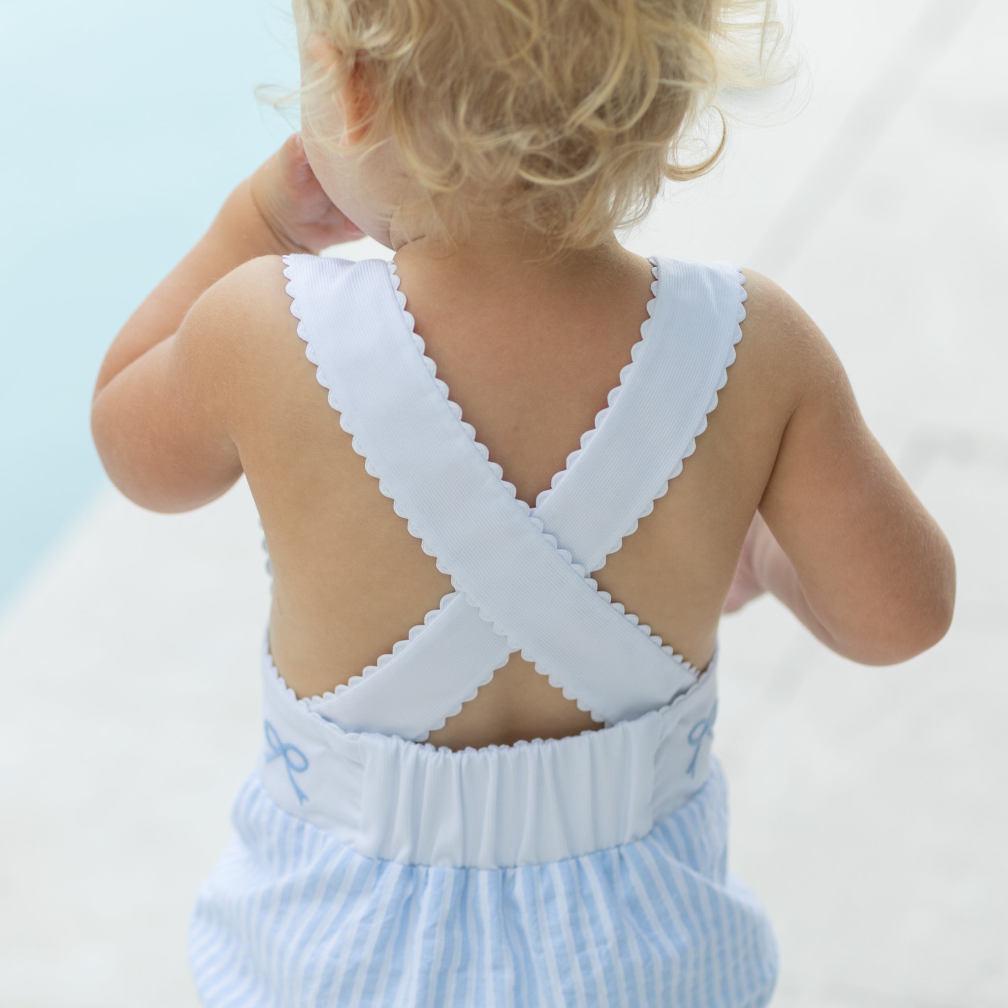 Back view of Henry Duvall Sutton Sunsuit showing criss-cross straps with ric rac trim on a classic baby girls sunsuit.