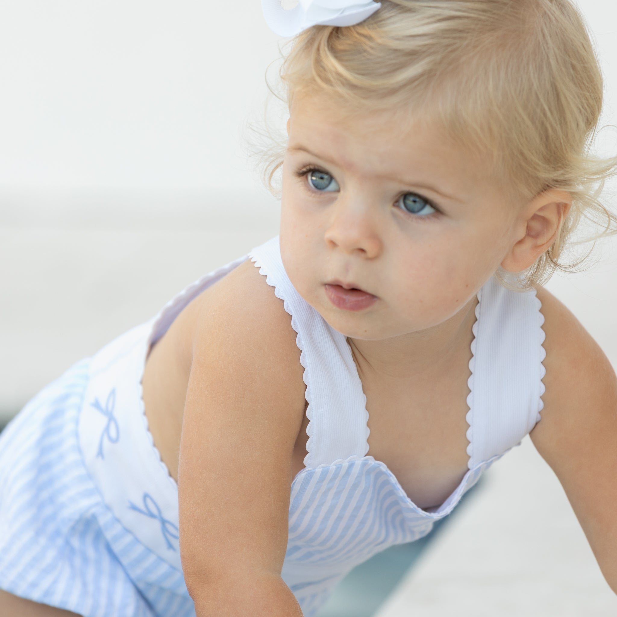 Baby girl wearing the Henry Duvall Sutton Sunsuit in Seaside Stripe, a classic summer outfit designed for warm weather and sibling matching.