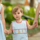 Henry Duvall Jennings Jon Jon with back-to-school embroidery, classic blue toddler boys romper with red trim and heirloom stitching of crayons, scissors, pencils, and ruler