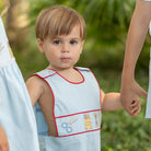 Henry Duvall Jennings Jon Jon with back-to-school embroidery, classic blue toddler boys romper with red trim and heirloom stitching of crayons, scissors, pencils, and ruler