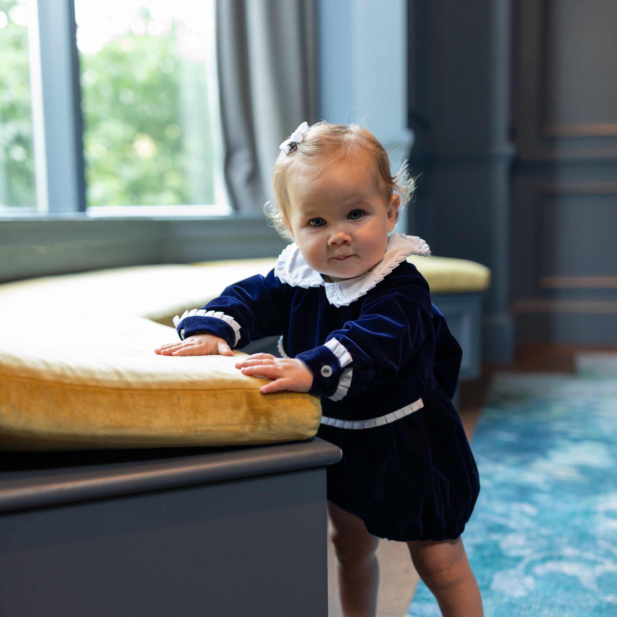 Baby girls navy velvet bubble with white pleated detailing and pre-tied bow, long sleeve fall outfit for special occasions and family photos by Henry Duvall