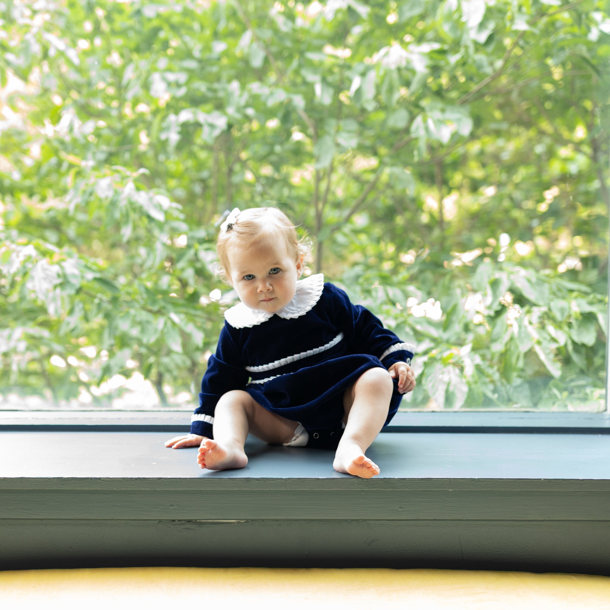 Baby girls navy velvet bubble with white pleated detailing and pre-tied bow, long sleeve fall outfit for special occasions and family photos by Henry Duvall