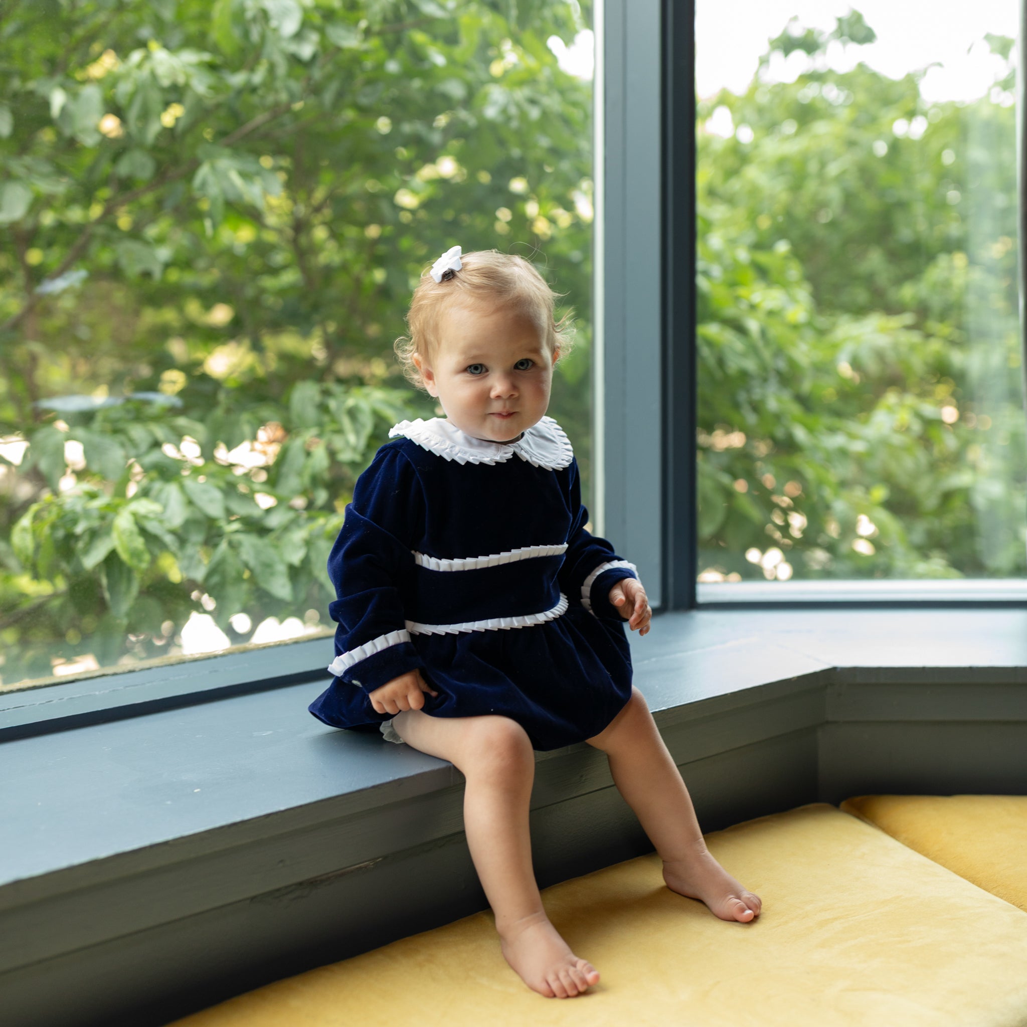 Baby girls navy velvet bubble with white pleated detailing and pre-tied bow, long sleeve fall outfit for special occasions and family photos by Henry Duvall