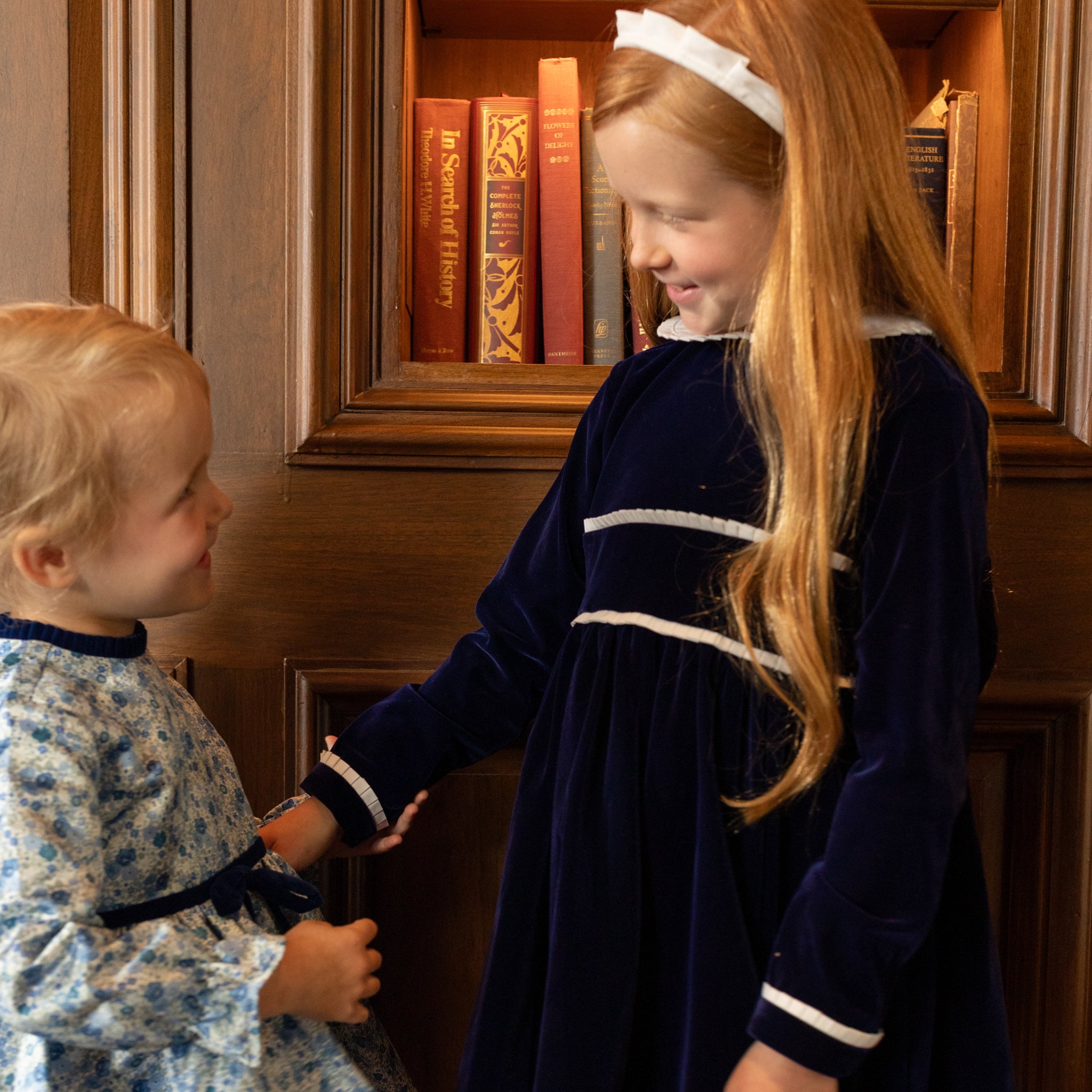 Girls long sleeve navy velvet party dress with white pleated details and pre-tied back bow, perfect for fall family photos and special occasions from Henry Duvall