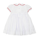 White short sleeve girls' holiday dress with red bow smocking across the chest, Peter Pan collar, and piped cuffs, classic Henry Duvall Eloise Dress for Christmas and winter family gatherings