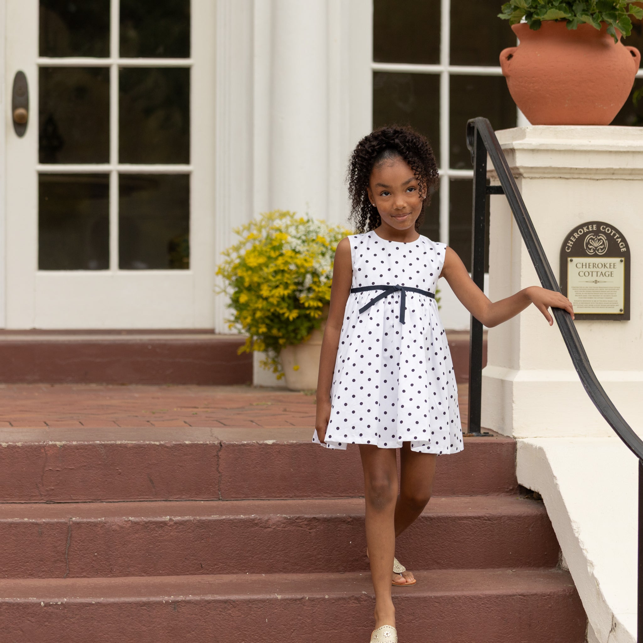 Henry Duvall Betsy Dress in white cotton with navy polka dots and grosgrain bow, classic twirl dress for girls that transitions from summer to fall