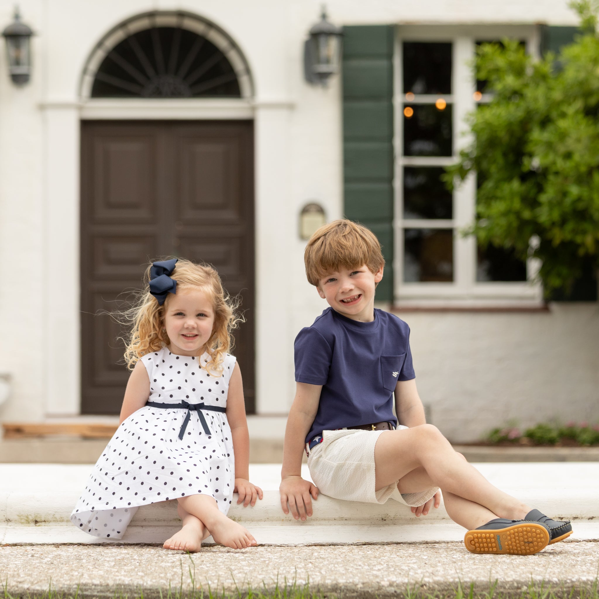 Henry Duvall Betsy Dress in white cotton with navy polka dots and grosgrain bow, classic twirl dress for girls that transitions from summer to fall