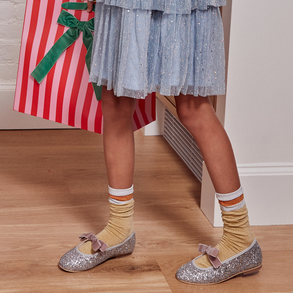 Meri Meri x Marjen Sabrina silver glitter Mary Jane with rose velvet bow, worn by child in a blue tulle skirt
