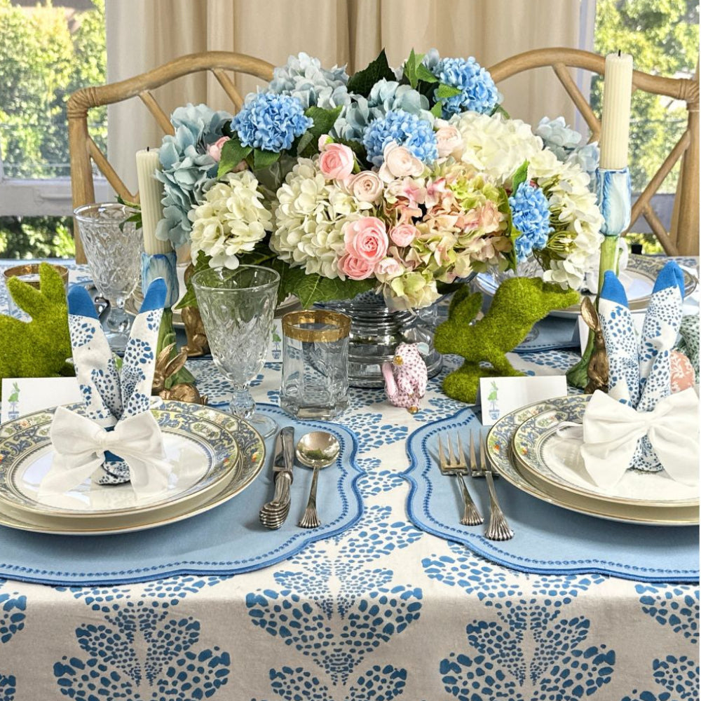 Elegant table setting with floral centerpiece, place settings, and decorative elements.