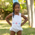 Henry Duvall unisex baby sunsuit in white with red and blue star appliqué and criss cross straps, classic patriotic outfit for Memorial Day, 4th of July, and summer occasions