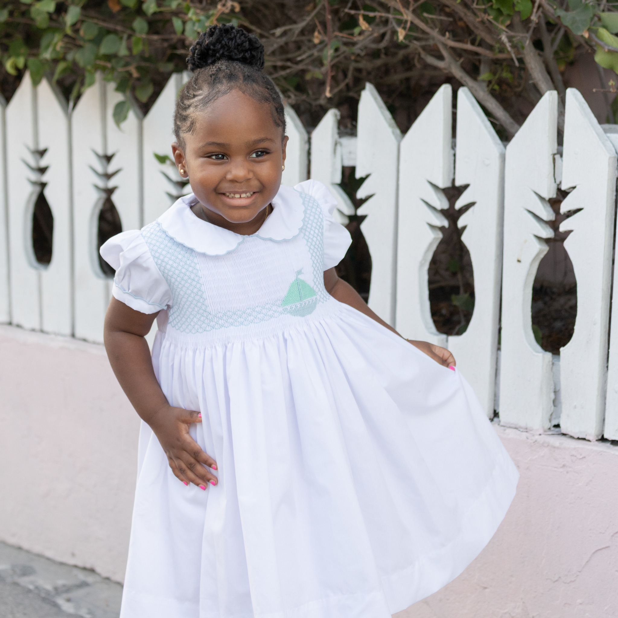 Henry Duvall Eloise Dress in white cotton with Bailey’s Bay Blue trim and hand-smocked sailboats, classic heirloom baby girl summer outfit with scalloped Peter Pan collar