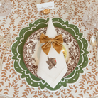 Classic round green scalloped placemats with white embroidery, perfect for Thanksgiving or holiday table settings, handcrafted from a premium cotton blend.