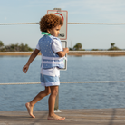 Boy wearing Henry Duvall Wyatt Shorts in East Beach Blue with striped cuffs, a classic boys short styled for spring days and timeless family moments