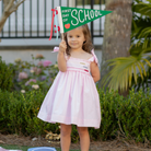 Henry Duvall Daisy Dress in blush pink cotton with hand-smocked crayon embroidery and shoulder bow ties, classic girls back-to-school dress for first day of school photos and fall occasions.