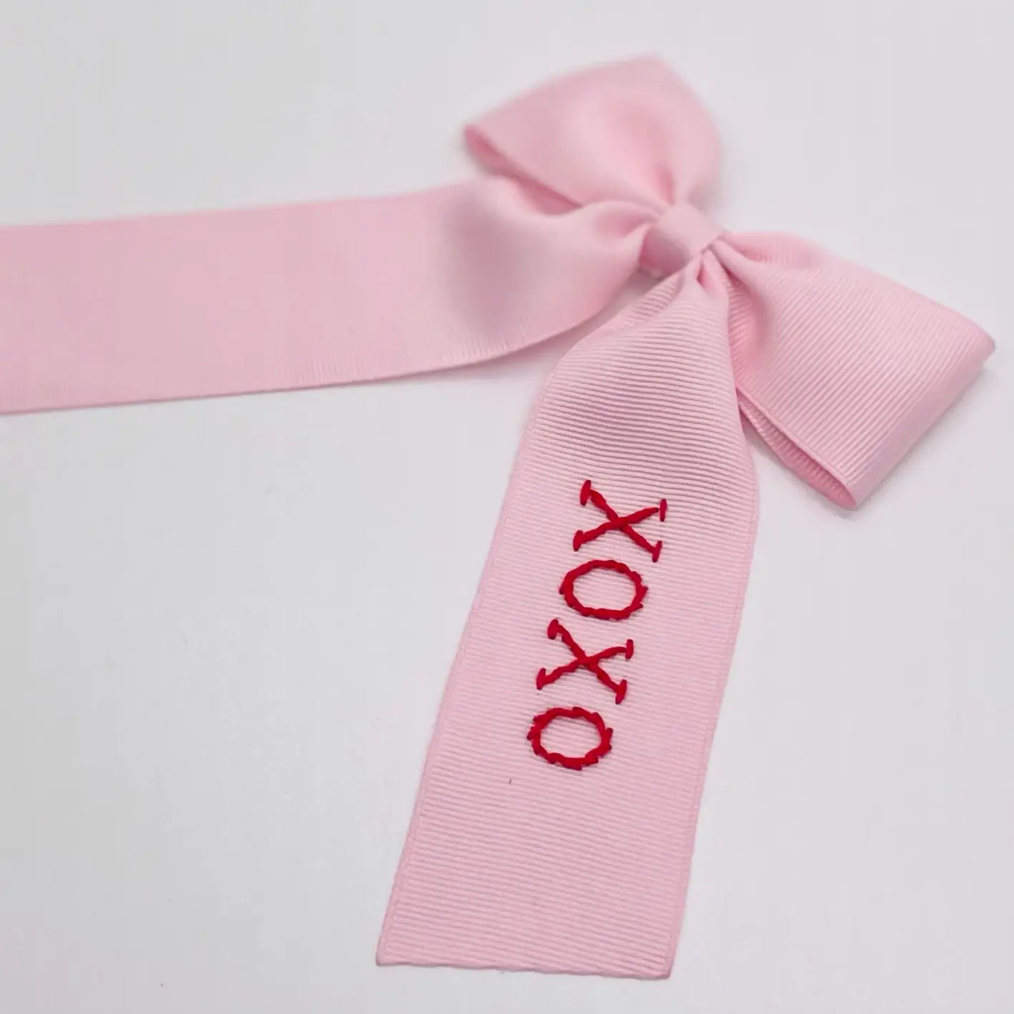 Hand-Embroidered XOXO Bow in pale pink with red stitched “XOXO", small valentine accessory