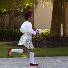 Girls’ Sutton Skirt in Regent Wreaths, featuring a festive green wreath and red star print on white with a full gathered silhouette.