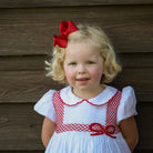 White short sleeve baby girl holiday bubble with red smocked bows, Peter Pan collar, and piped cuffs, classic Eloise Bubble by Henry Duvall for Christmas and winter celebrations