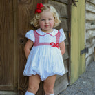 White short sleeve baby girl holiday bubble with red smocked bows, Peter Pan collar, and piped cuffs, classic Eloise Bubble by Henry Duvall for Christmas and winter celebrations
