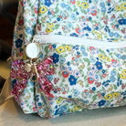 Pink glitter bow keychain for girls, made of sparkly acrylic with a hand-sprinkled confetti finish; cute holiday stocking stuffer or gift accessory