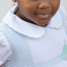 Henry Duvall Eloise Dress in white cotton with Bailey’s Bay Blue trim and hand-smocked sailboats, classic heirloom baby girl summer outfit with scalloped Peter Pan collar
