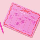 Hot pink weekly planner with bow detail, styled as a Christmas gift for girls ages 10–12