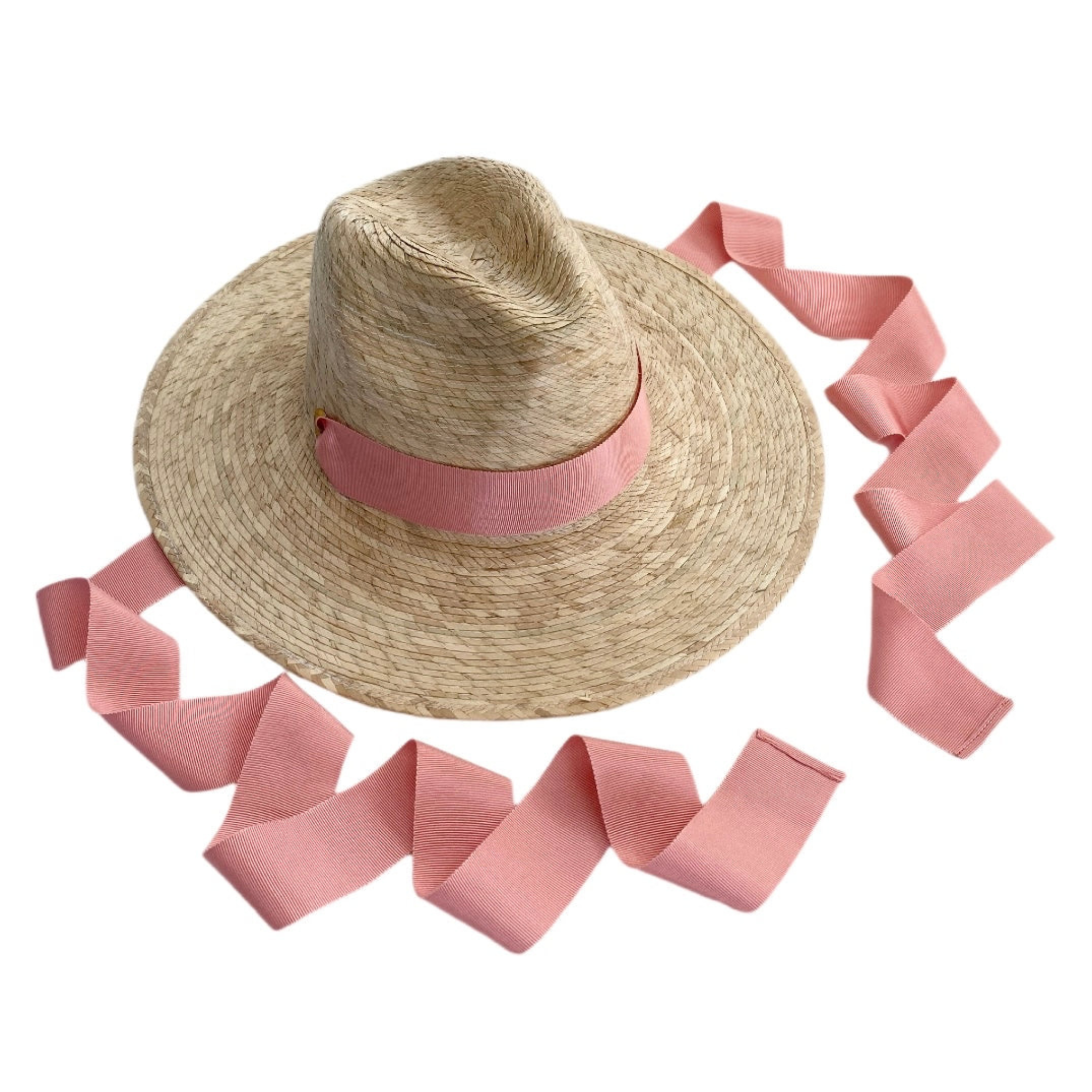 Straw hat with a pink ribbon on a white background
