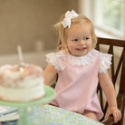 Henry Duvall Rosie Bubble for baby girls in pink piqué, a classic baby girls bubble with lace angel sleeves and satin bow details.