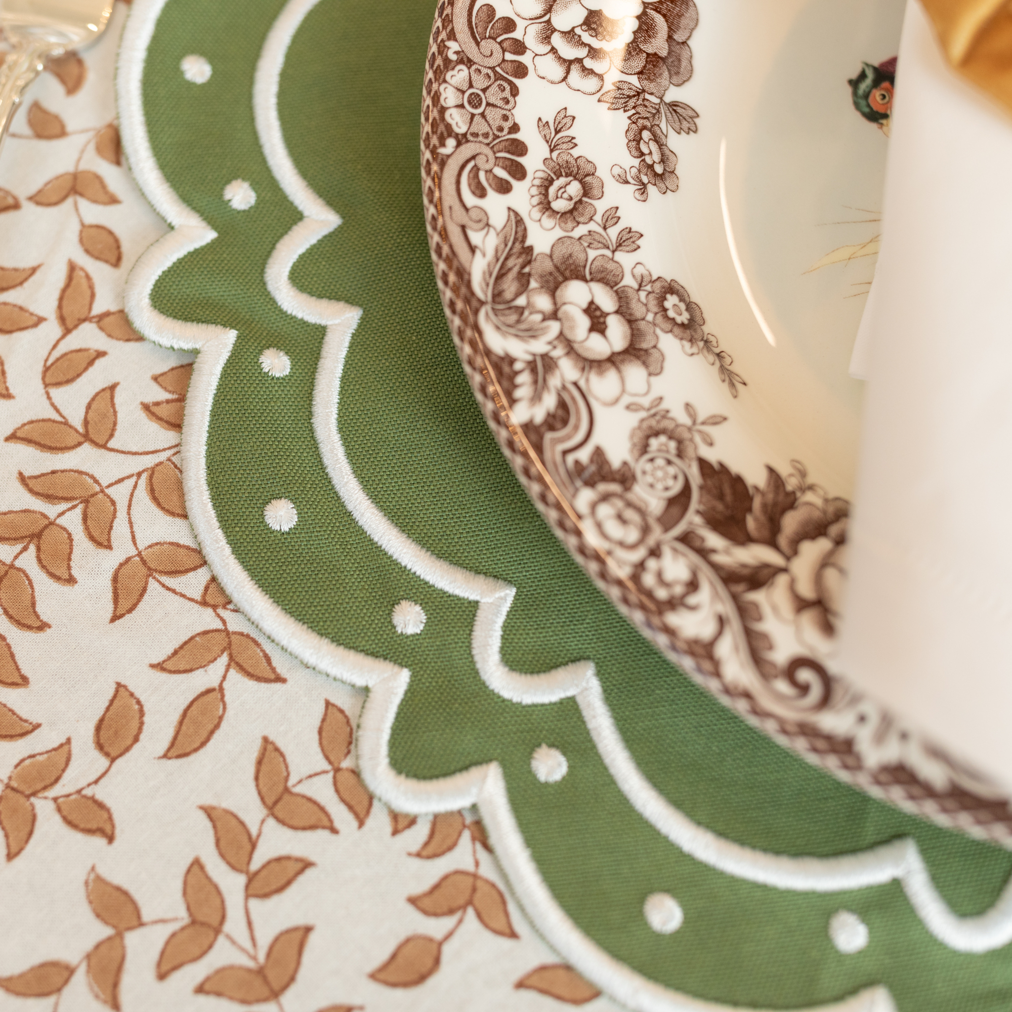 Classic round green scalloped placemats with white embroidery, perfect for Thanksgiving or holiday table settings, handcrafted from a premium cotton blend.