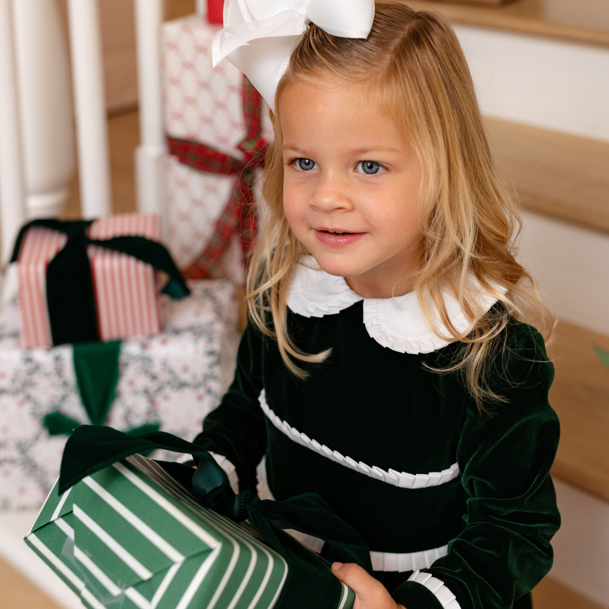 Baby girls’ Long Sleeve Grace Bubble in Grafton Green Velvet with a white pleated collar, waist and cuff trim.