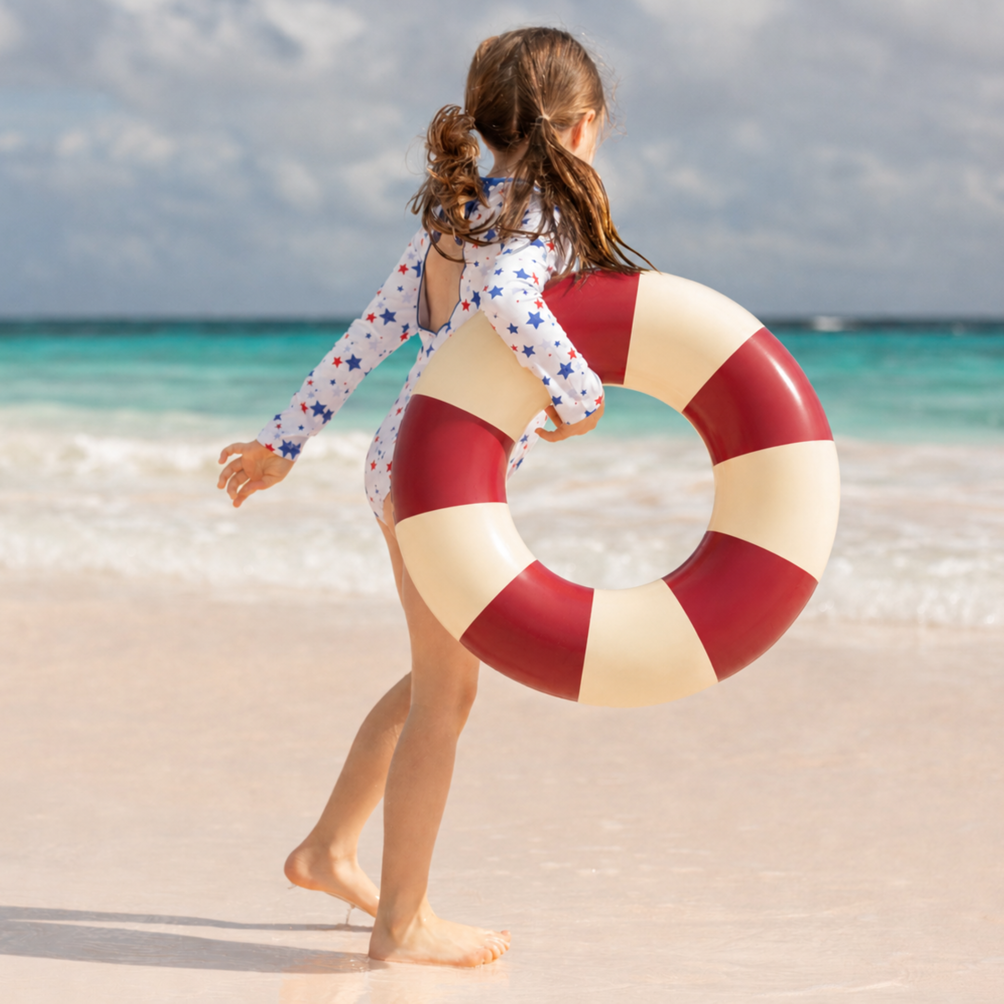 Henry Duvall Reese girls rashguard one piece in red white and blue star print, UPF 50+ long sleeve swimsuit for 4th of July, beach, and summer holidays