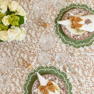 Golden velvet bow napkin ties styled for a Thanksgiving table setting with brown floral china and green scalloped placemats from Henry Duvall.