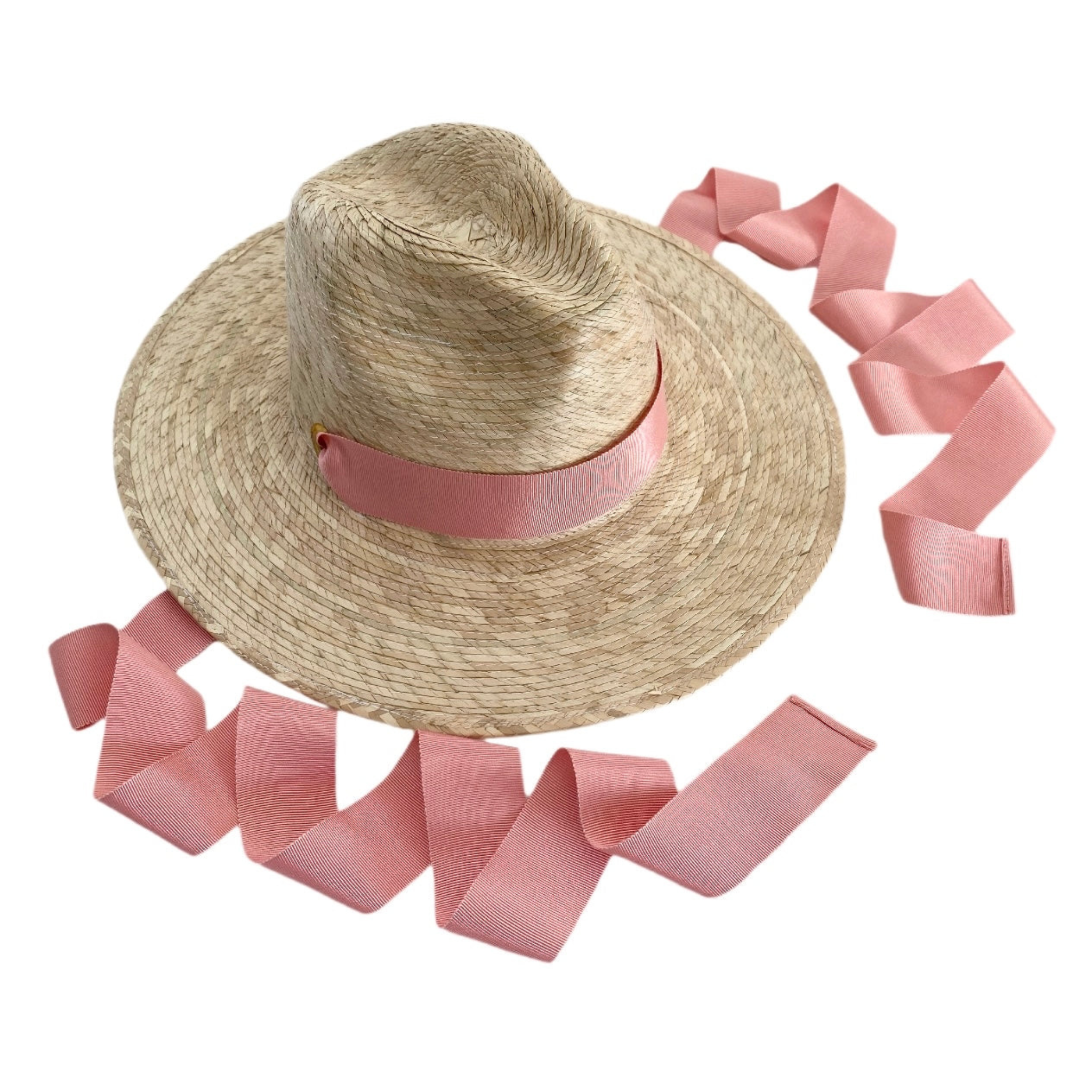 Straw hat with a pink ribbon on a white background