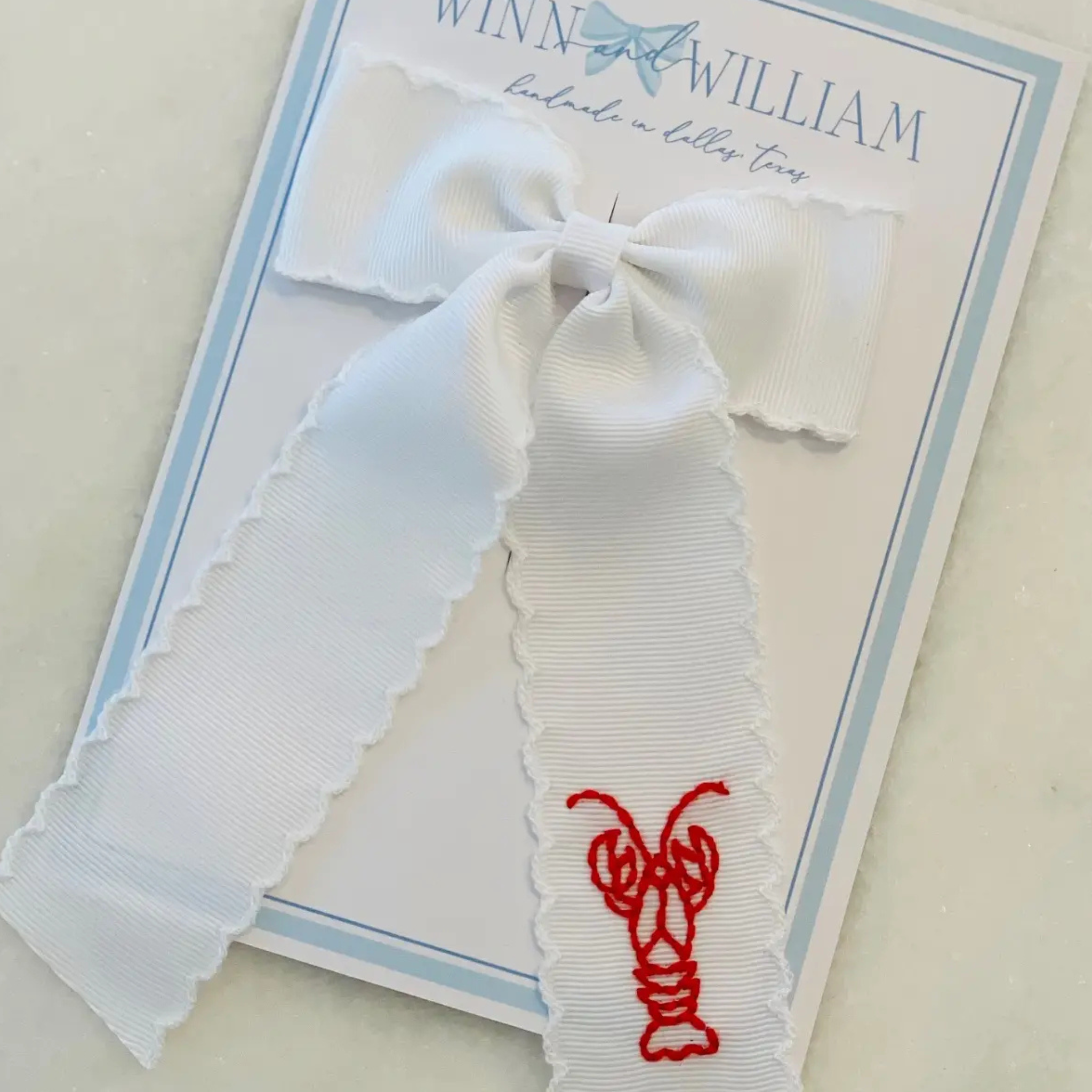 White bow with red hand-embroidered crawfish and white moonstitch trim, springtime kids accessory