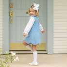 Henry Duvall Janie Jumper girls’ dress in Brookhaven Blue corduroy with scalloped hem and fabric-covered shoulder buttons, designed for layering with blouses and turtlenecks for fall.
