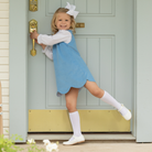 Henry Duvall Janie Jumper girls’ dress in Brookhaven Blue corduroy with scalloped hem and fabric-covered shoulder buttons, designed for layering with blouses and turtlenecks for fall.